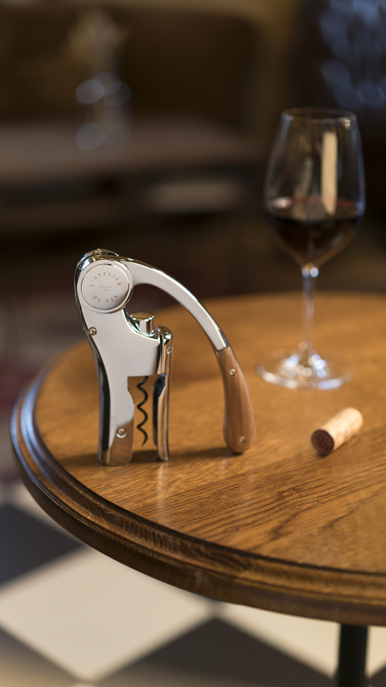 Oeno Motion Wood & Chrome vertical lever corkscrew on table with wine