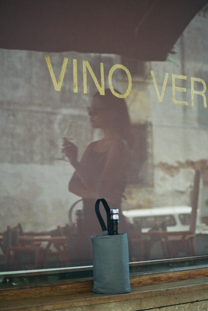 Grey linen wine cooler and bottle holder on the front of a shop window in the streets of Venice